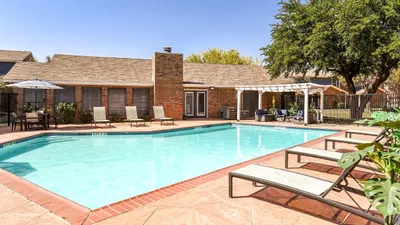 Inviting outdoor pool area with lounge chairs and a shaded seating area, perfect for relaxing under the sun.
