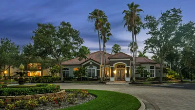 Elegant residential property with a beautifully landscaped entrance, vibrant garden, and a grand facade under a serene evening sky.