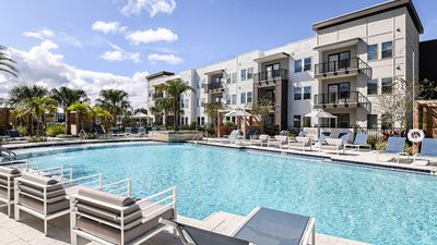 Expansive resort style pool with cabanas and outdoor chaise lounges.