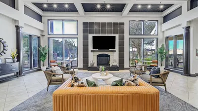 Luxurious modern living room with tall windows, sleek decor, and chic furniture, perfect for relaxation and entertaining.