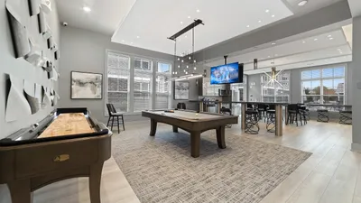 Luxurious entertainment lounge featuring modern decor, pool table, shuffleboard, and stylish seating.
