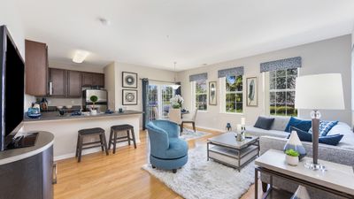 Bright and modern open-plan living area featuring elegant hardwood floors, cozy seating, and a stylish kitchen. Perfect blend of comfort and sophistication.