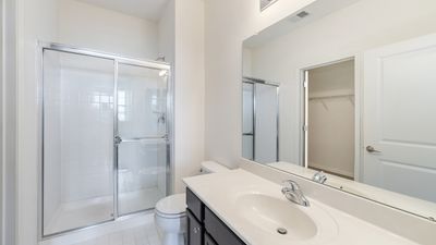 Contemporary bathroom with sleek fixtures, a spacious glass shower, and a stylish white vanity.
