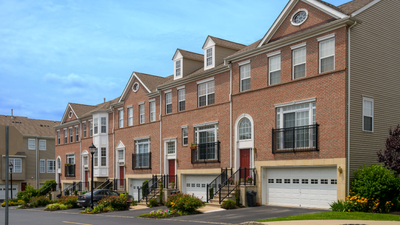 Charming row of brick townhouses with elegant bay windows and landscaped front gardens.