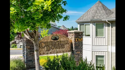 Inviting exterior view of Churchill Downs Apartments, featuring elegant architecture and lush green surroundings.