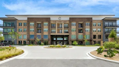 Elegant modern apartment building with beautiful landscaping and spacious balconies, perfect for luxury living.