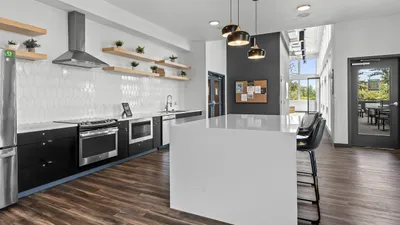 Modern kitchen with sleek appliances, stylish pendant lighting, and open shelving, ideal for culinary enthusiasts.
