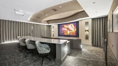 Luxurious private screening room with modern seating, plush carpeting, and a large cinematic screen for an ultimate viewing experience.