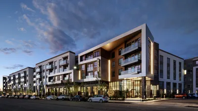 Modern apartment complex at dusk featuring stylish architecture, balconies, and well-lit exteriors.