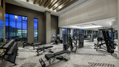 Modern fitness center with state-of-the-art exercise equipment, sleek design, and large windows overlooking a scenic view.