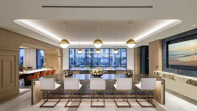 Elegant modern kitchen and dining area with sleek countertops, stylish pendant lighting, and large windows offering scenic city views.