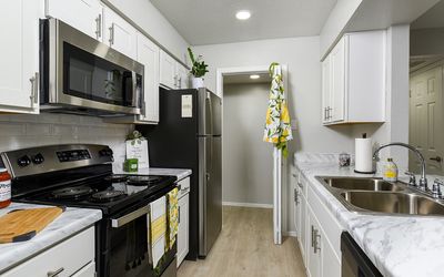 Modern kitchen with sleek stainless steel appliances, elegant white cabinetry, and chic marble countertops.