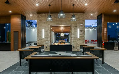 Luxurious open-air lounge area with modern seating, ambient lighting, and a stunning centerpiece fireplace, perfect for elegant gatherings.