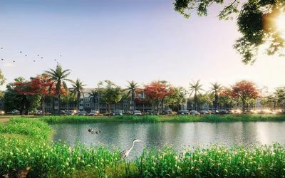 Serene apartment complex nestled by a tranquil lake, adorned with vibrant foliage and palm trees under a bright, sunlit sky.