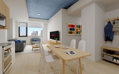 Modern open-plan apartment with sleek kitchen, cozy living area, and stylish dining space, featuring a blue ceiling accent and natural light.