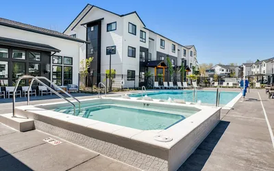 Resort-style swimming pool and spa with apartment buildings at The Preserve on Goodpasture Eugene Oregon