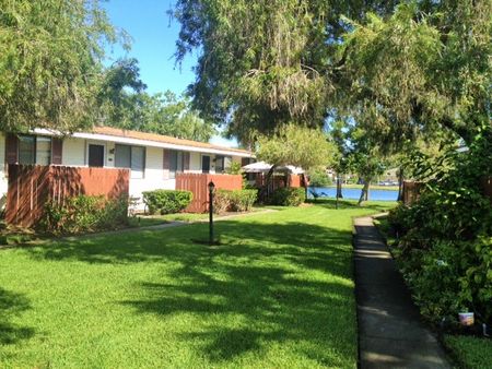 Clubside Apartment Homes, exterior, grass, trees, white building, red fence