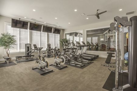 Fitness Center with 2 treadmills, 2 stationary bikes, 2 leg machines, 2 smith machines, free weights, and 4 flat screen television with a view of the playroom