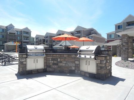 2 stainless steel grills and granite counter-top facing the pool