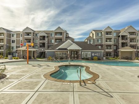 Concord pool area showing double infinity jacuzzi in front of pool and splash-pad with surrounding cabanas and activity center.