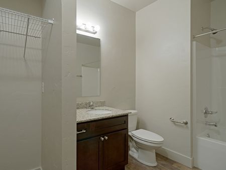 Full guest bathroom showing connected laundry area