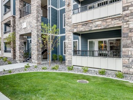 Apartment exterior showing patio overlooking grass area