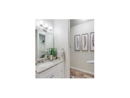 Guest bathroom showing vanity with white cabinets and laundry area entrance
