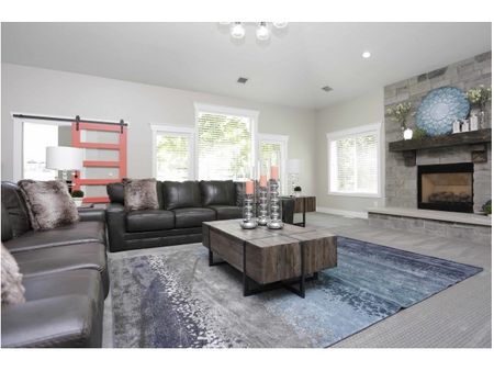 Clubhouse waiting room with 2 couches, coffee table, flat screen television, and fireplace