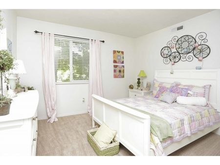 Second bedroom with full bed, large window, nightstand and dresser.
