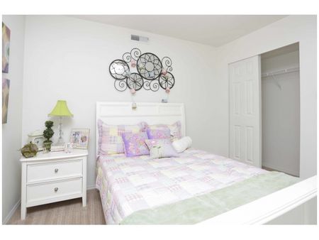 Second bedroom with full bed and nightstand and sliding door closet