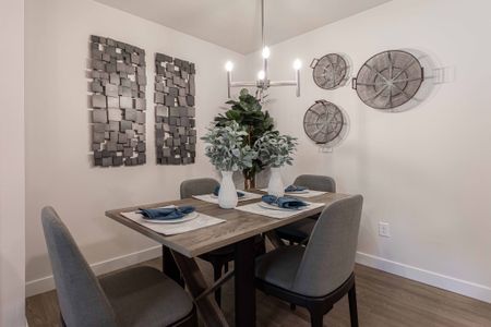 Spacious Dining Room featuring two tine pain, modern style chandelier, and modern industrial style table and chairs. Photo features the hardwood flooring and lighting, offering a versatile space able to accommodate various dining room setti