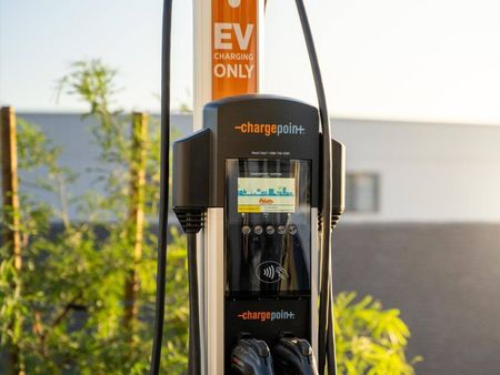 Glendale, AZ Apartments - Acero At the Stadium - Electric Vehicle Charging Station With Bush In The Background.