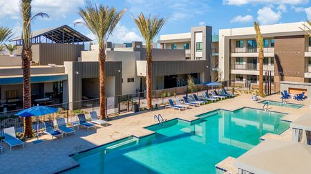 Apartments For Rent In Queen Creek, AZ - Acero Harvest Station - View From Above Of The Large Pool And Relaxing Lounge Area Surrounded By Tall Palm Trees