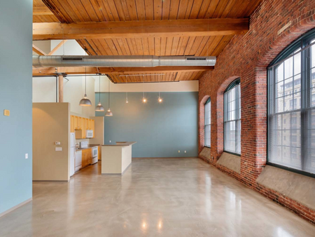 Kitchen-serving community serving area with soaring ceilings, tall windows in brick walls at Washington Mill 240 | Lawrence, MA Apartments.