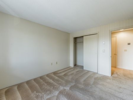 Carpeted bedroom with closet with sliding doors  in apartment at at Westford Park apartments in Lowell, MA.