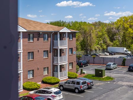 Exterior view of building with parking at Westford Park apartments in Lowell, MA.