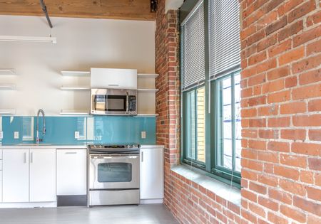 Natural lighting in  kitchen, exposed brick wall and ceiling beams | 381 Congress Lofts | Apartments in Downtown Boston