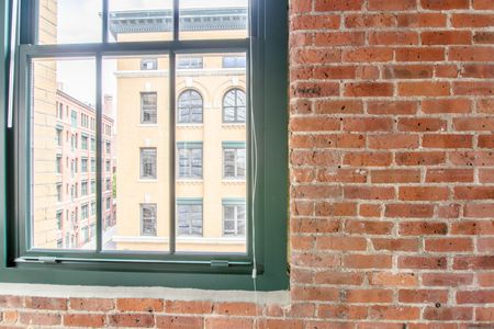 Closer look at the windows consisting of individual panes set into an exposed brick wall |  381 Congress Lofts | Apartments in Downtown Boston