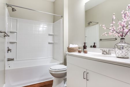 View of Bathroom, Showing Single Vanity, Toilet, and Garden Tub at Alpha Mill Apartments