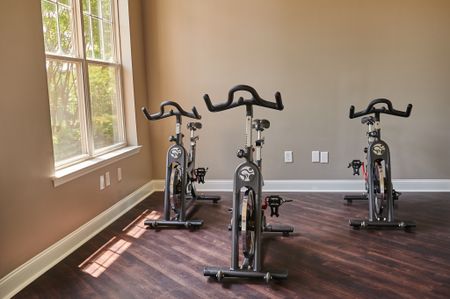 View of Spin and Yoga Studio, Showing Spin Bikes, Plank Flooring, and Window at Cottonwood Reserve Apartments