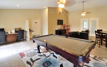 View of Clubroom, Showing Pool Table, Lounge Seating, Business Center Area with Monitors and Desks at Camelot Apartments