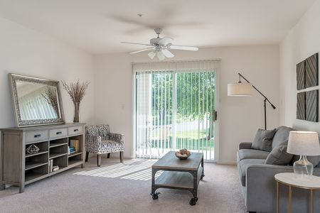 View of Furnished Living Room, Showing Couch, Carpet, Ceiling Fan, Sliding Glass Door and Décor at Clearview Apartments