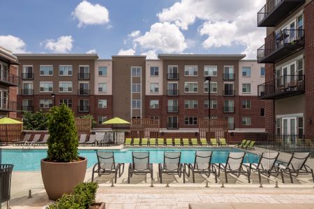 View of Pool Area, Showing Loungers, Umbrellas, and Apartment Buildings Surrounding at The Melrose Apartments