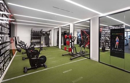 Mirrored grassy indoor area with fitness equipment and virtual fitness options at Modera San Diego apartments.