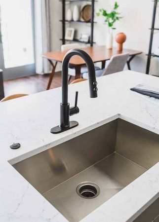 Close up of quartz countertops and large basin sink in apartment at at Modera Old Ivy