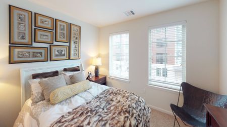 Bedroom with large windows and plush carpeting
