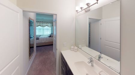 Bathroom with quartz countertop and modern vanity lighting