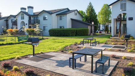 Outdoor grilling area with table and chair setting near the Woof N Wag Park