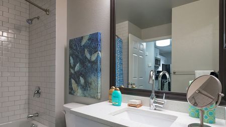 Redesigned Bathrooms with Granite Counters and Tile Surrounds