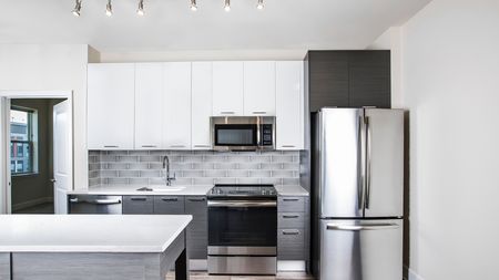 Elegant Kitchen Featuring Modern White Upper Cabinetry in apartment at Modera Mosaic.